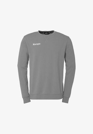 Grå sweatshirt lavet af bomuldsblanding. Har lange ærmer, rund hals og et hvidt "Kempa" logo på brystet. Glat tekstur, minimalistisk design.