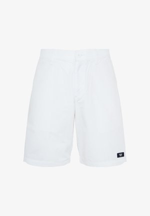 Pantaloncini bianchi fino al ginocchio con passanti per cintura, bottone frontale e cerniera, e una piccola toppa con logo nero sull'orlo della gamba sinistra.