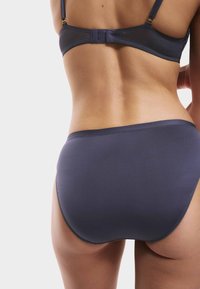 Marinblå bikini-set med en slät textur, justerbara band och en minimal design. Underdelen har en klassisk täckning.