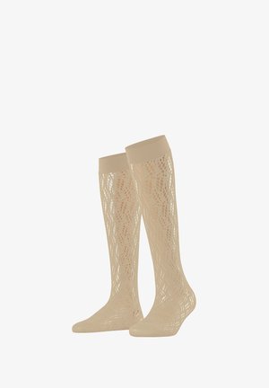 Beżowe, sięgające do kolan koronkowe skarpetki z falistym, ażurem i solidnymi elastycznymi mankietami.