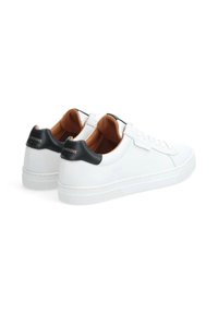 Baskets en cuir blanc avec une semelle en caoutchouc texturé, ornées d'un capuchon de talon noir contrastant et d'un intérieur beige. Design à lacets à l'avant.