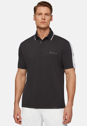 Sort polo shirt lavet af bomuldsblanding, med en tre-knaps knappelukning, hvide detaljer på skuldrene og et guld-logo på brystet.