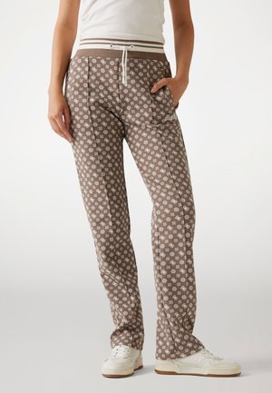 Pantaloni sportivi marroni a motivi con disegni geometrici bianchi, vita elastica con cordoncino, tasche laterali e accentuazione del logo sull'anca.