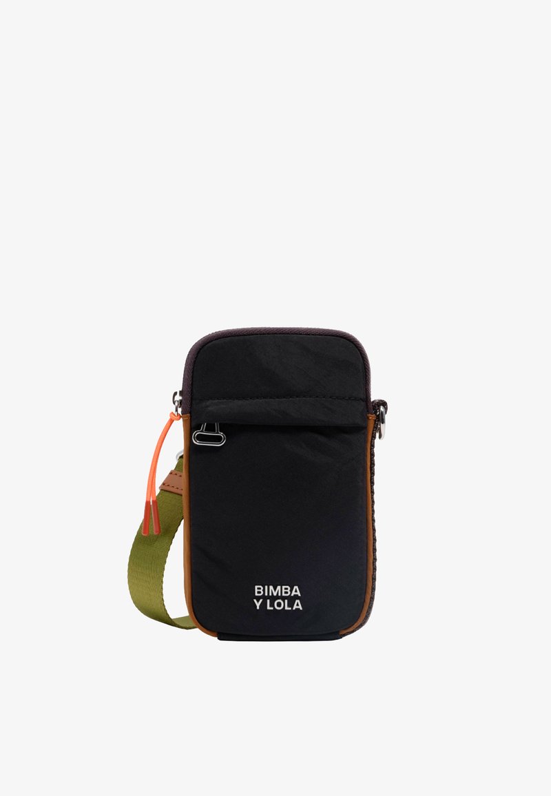 Črn najlon crossbody nahrbtnik z rjavim usnjenim obrobom, nastavljivim zelenim trakom, sprednjim žepom z zadrgo in oranžnim zadrgo za poteg. Logotip je jasno viden.
