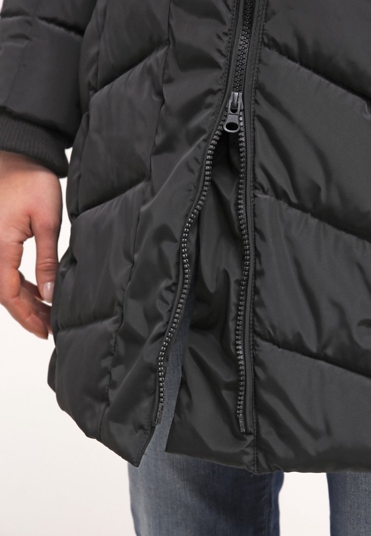 Chaqueta de plumas negra con un diseño acolchado, que presenta un cierre frontal y puños acanalados. La textura parece suave y brillante.