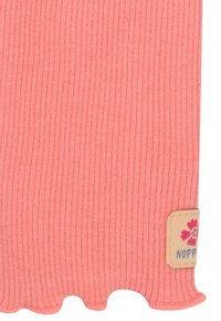 Tissu en velours côtelé corail avec un bord festonné ; présente une petite étiquette décorative avec un motif floral et le texte "NOPP."