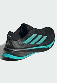 Černá sportovní bota s vrchní částí z poddajné síťoviny, tyrkysovými akcenty, polstrovanou mezipodešví a texturovanou podešví. Obsahuje design se třemi pruhy.