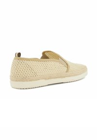 Beige, breathable slip-on shoes with a textured mesh upper and elastic side panels, featuring a light-colored sole and a small back loop.