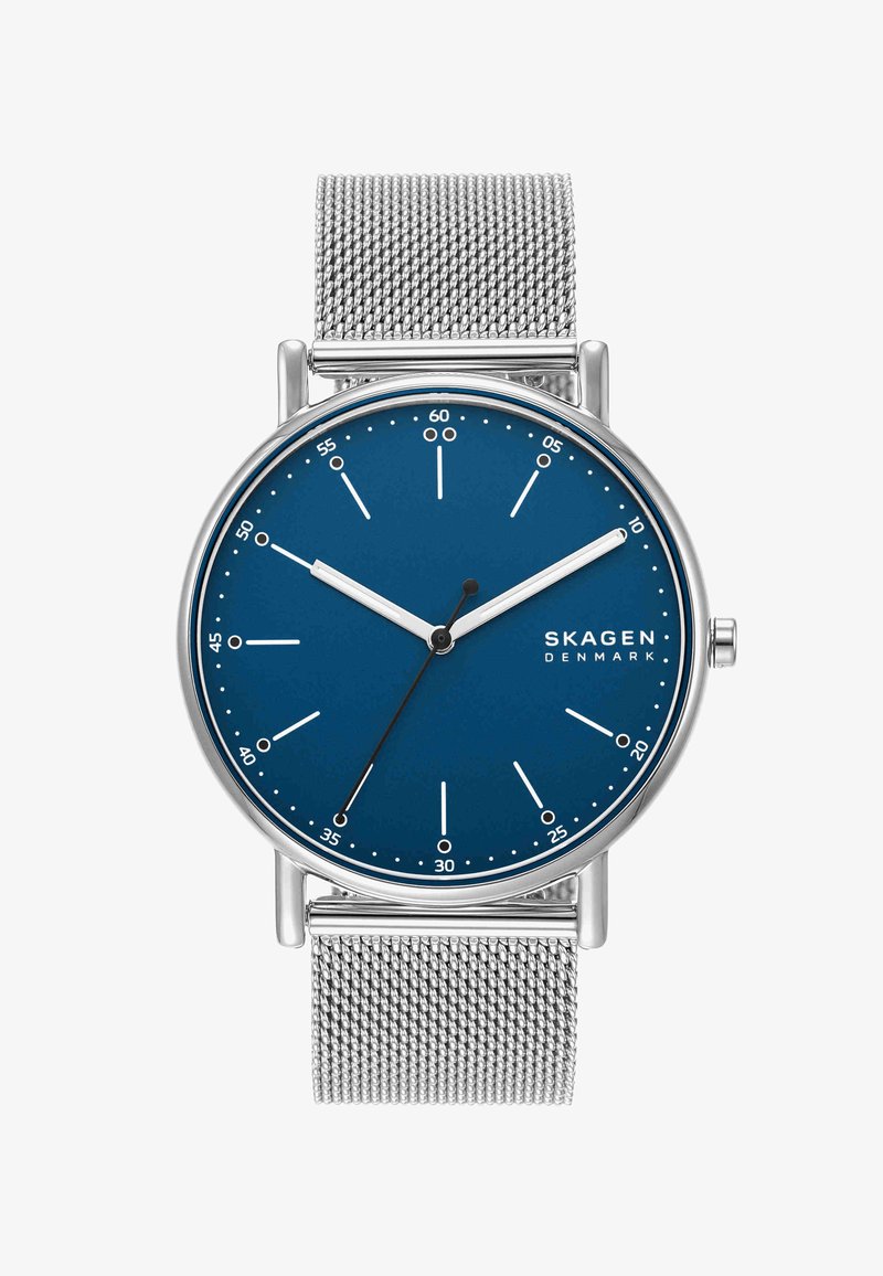 Reloj con correa de malla plateada, esfera azul, agujas blancas de horas y minutos, aguja negra de segundos y logotipo de Skagen Denmark a las 3 en punto.