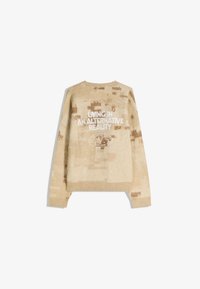 Bežani pleteni pulover s kamuflažnim uzorkom, okruglim izrezom i rebrastim rukavima. Na leđima je natpis "ŽIVOT U ALTERNATIVNOJ STVARNOSTI."