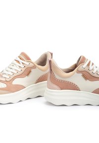 Zapatillas beige y rosa claro con materiales de gamuza y cuero, que cuentan con cordones blancos y acentos de costura, punta redondeada y suela gruesa.
