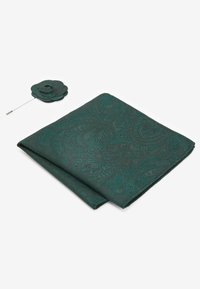 Pochette de costume en velours texturé de couleur vert foncé, ornée d'un motif paisley, accompagnée d'une épingle à fleur assortie.