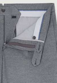 Pantaloni grigi con motivo pied de poule, dotati di chiusura con cerniera, tasche laterali e cinturino interno a contrasto. I materiali includono tessuto strutturato e cotone.