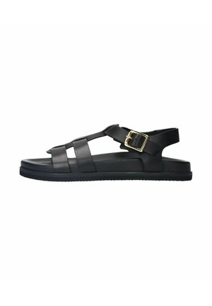 Black sandals made of synthetic material with crisscross straps, adjustable buckle, flat sole, and textured grip. No heel.