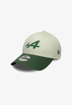 Baseball cap with light beige crown and dark green curved brim, featuring green embroidered stylized "A" on front and New Era logo on side.