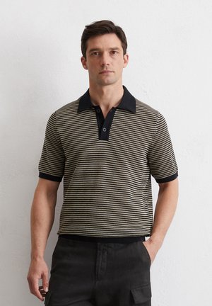 Gestreepte poloshirt met een zwarte kraag, voorzien van een geweven structuurpatroon in crème en donkerbruin. Korte mouwen, klassieke pasvorm.