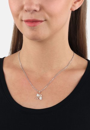 Collar de cadena de plata con un colgante de oro rosa que presenta un detallado diseño de ángel y acentos claros, exhibido en una persona que lleva una blusa negra.