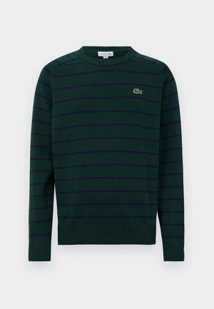 Dark green long-sleeve sweater with navy horizontal stripes and a small embroidered crocodile logo on the left chest.