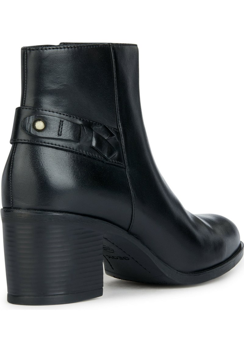 Schwarze Leder-Stiefelette mit runder Zehenpartie, strukturiertem Blockabsatz und geflochtenen Riemen mit dekorativem Knopf.