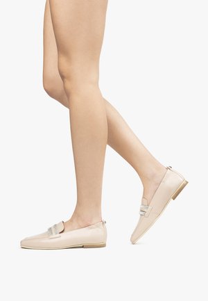 Beige læder loafers med en glat tekstur, udstyret med et dekorativt sølvfarvet accentbånd og en lav træhæl.
