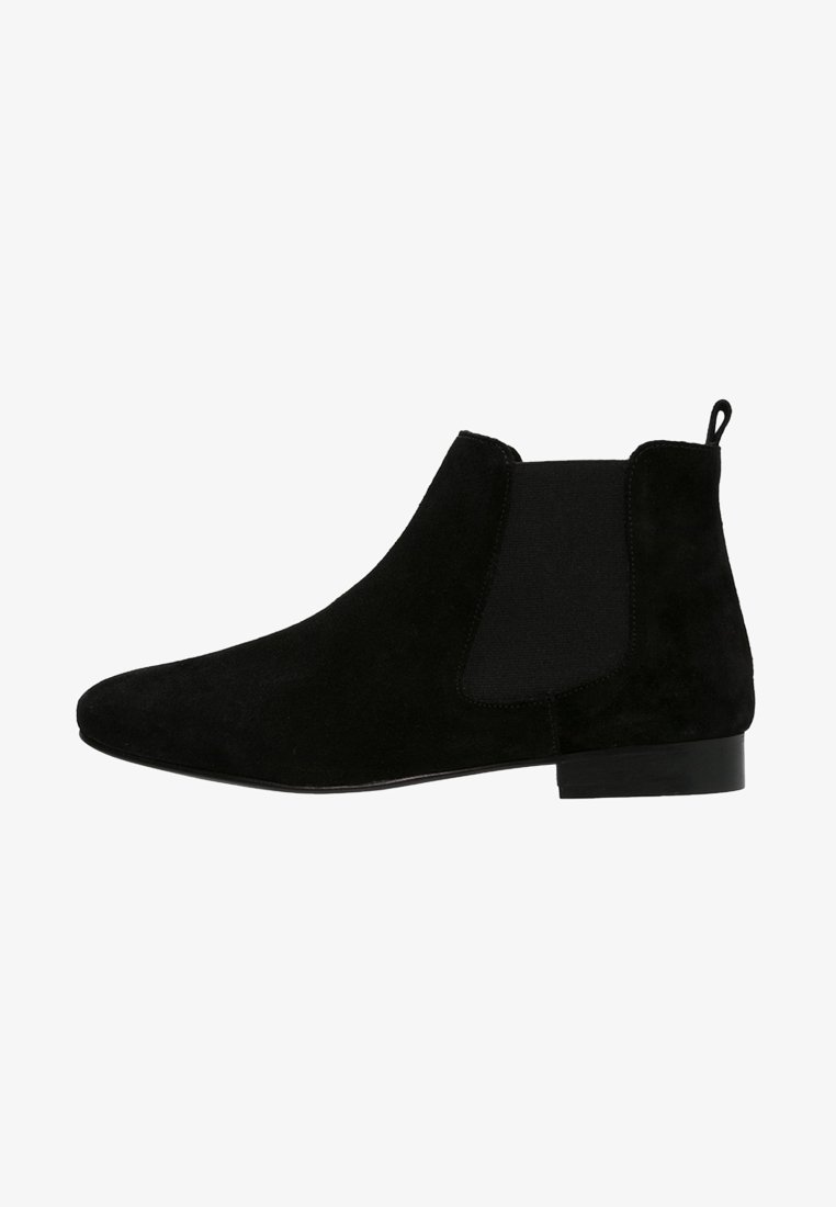 Botte Chelsea en daim noir avec panneau latéral élastique, languette à l'arrière et petit talon empilé.