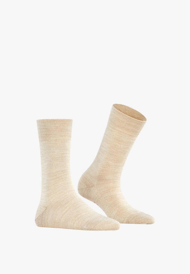Chaussettes beiges de longueur mi-mollet fabriquées en matériau doux et texturé, avec une finition lisse et des zones de orteil et de talon renforcées.