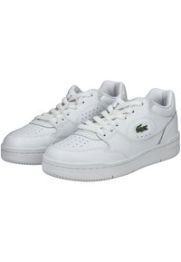 Weiße Ledersneaker mit perforierten Details, flachen Schnürsenkeln, einem gepolsterten Schaft und einem kleinen grünen Krokodil-Logo an der Seite. Gummisohle.