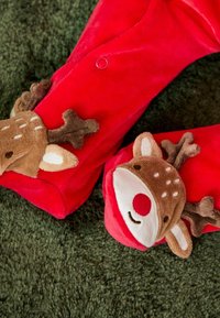 Rote Fleece-Hausschuhe mit kuscheligen Rentiergesichtern, braunen Hörnern und einer roten Nase, verziert mit gestickten Augen und Mund.