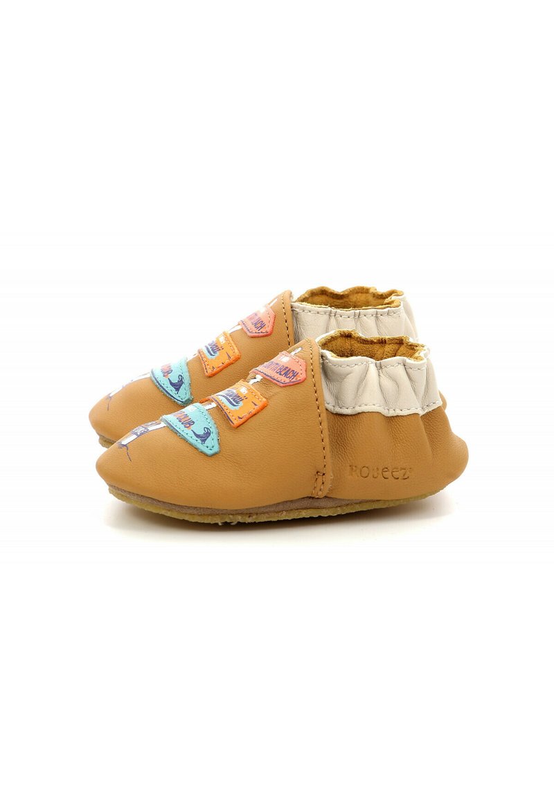Botines de cuero marrón claro con un suave cuello elástico blanco. Presentan parches de tela coloridos y una suela flexible para mayor comodidad.