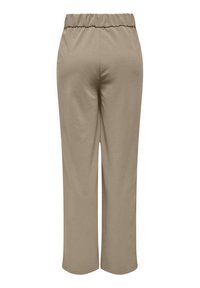 Pantalons beiges à la texture lisse, taille élastique et coupe évasée. Vue arrière ne montrant ni poches ni détails supplémentaires.