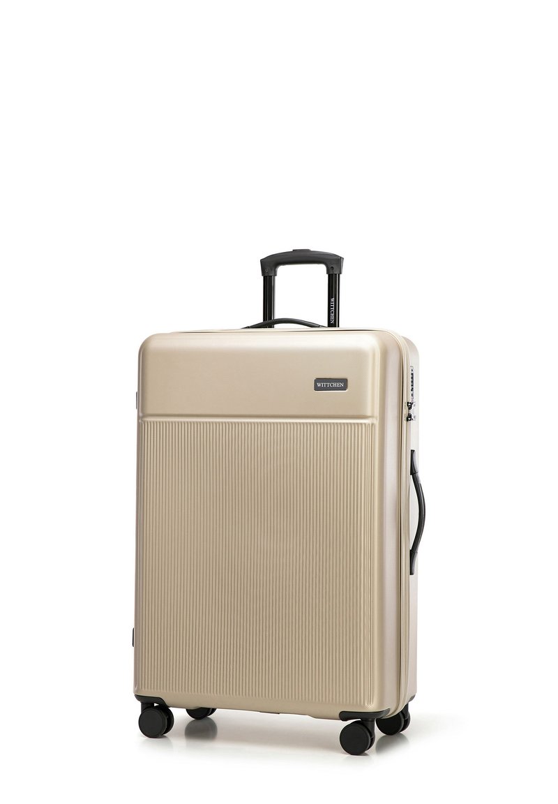 Gouden harde koffer met verticale ribbels, een intrekbare handgreep en vier zwarte wielen. Het merklogo staat aan de voorkant. Ideaal voor reizen.