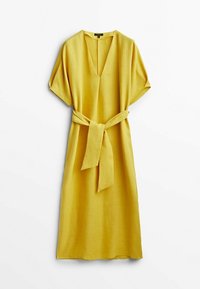 Robe en lin jaune avec un décolleté en V, des manches courtes et une ceinture à nouer à la taille. Le tissu a une texture lisse et un design ample et fluide.