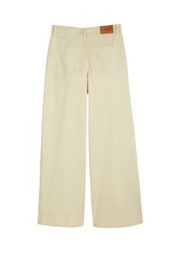 Spodnie o szerokich nogawkach z jasnobeżowej bawełny, z dwoma tylnymi kieszeniami i brązową metką marki przy pasku. Gładka tekstura.
