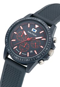 Montre Nautica avec un bracelet en caoutchouc noir, un cadran noir, des accents rouges et des fonctionnalités de chronographe. Comprend des éléments en argent et un affichage de la date.