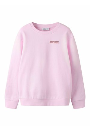 Sweat-shirt rose clair à col rond avec manches longues et le mot "CONFIDENT" imprimé en marron sur le côté supérieur gauche de la poitrine.