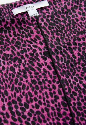 Pink fabric featuring a black leopard print pattern, with a textured finish. The product label is visible at the top.