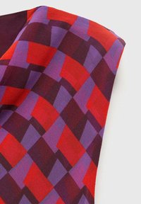 Multicolored fabric featuring a geometric pattern of red, purple, and dark burgundy squares and rectangles with a smooth texture.