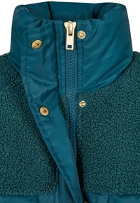 Tyrkysová bunda s texturovanou fleecovou horní částí, hladkým nylonovým spodkem, zlatým zipem a cvokovými uzávěry, vysokým límcem a kontrastními materiály.