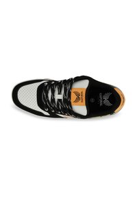 Sneaker bianco e nero con tomaia perforata, lacci testurizzati e un vivace patch logo arancione. Suola robusta con accenti decorativi.