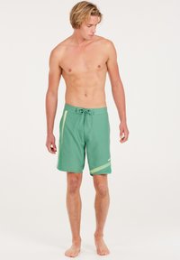 Groene zwemshorts met een trekkoord in de taille, lichtgroene zijaccenten en een logo op het onderbeen. Gemaakt van lichtgewicht, sneldrogend materiaal.