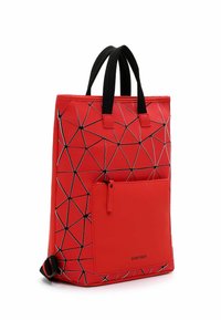 Rote Tragetasche mit einem geometrischen schwarz-weißen Muster, ausgestattet mit zwei schwarzen Griffen, einer Reißverschluss-Vordertasche und einer glatten, glänzenden Oberfläche.