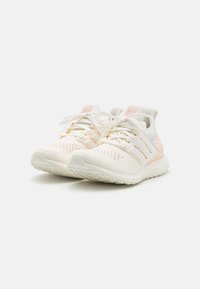 Weiße und hellrosa Sportschuhe mit Mesh-Obermaterial, strukturiertem Muster, dicker Sohle, auffälligen Schnürsenkeln und Markenlogo an der Seite und am Heck.