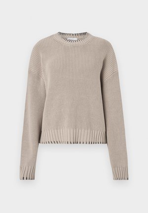 Suéter de punto beige con cuello redondo, hombros caídos y dobladillo acanalado. Presenta un patrón texturizado y detalles contrastantes en negro en los puños.