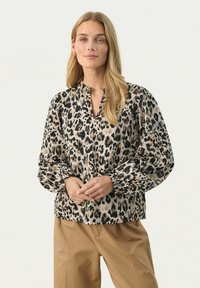 Langärmlige Bluse aus Tierdruckstoff, mit einem Schlüssellochausschnitt, elastischen Bündchen und lockerer Passform in Beige- und Schwarztönen.