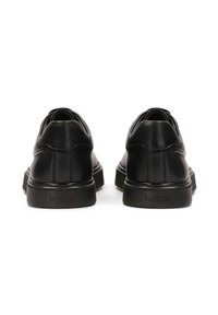Pantofi din piele neagră cu o textură netedă, vârf rotunjit și talpă neagră contrastantă. Prezintă un logo pe toc. Concepuți pentru purtare casual.