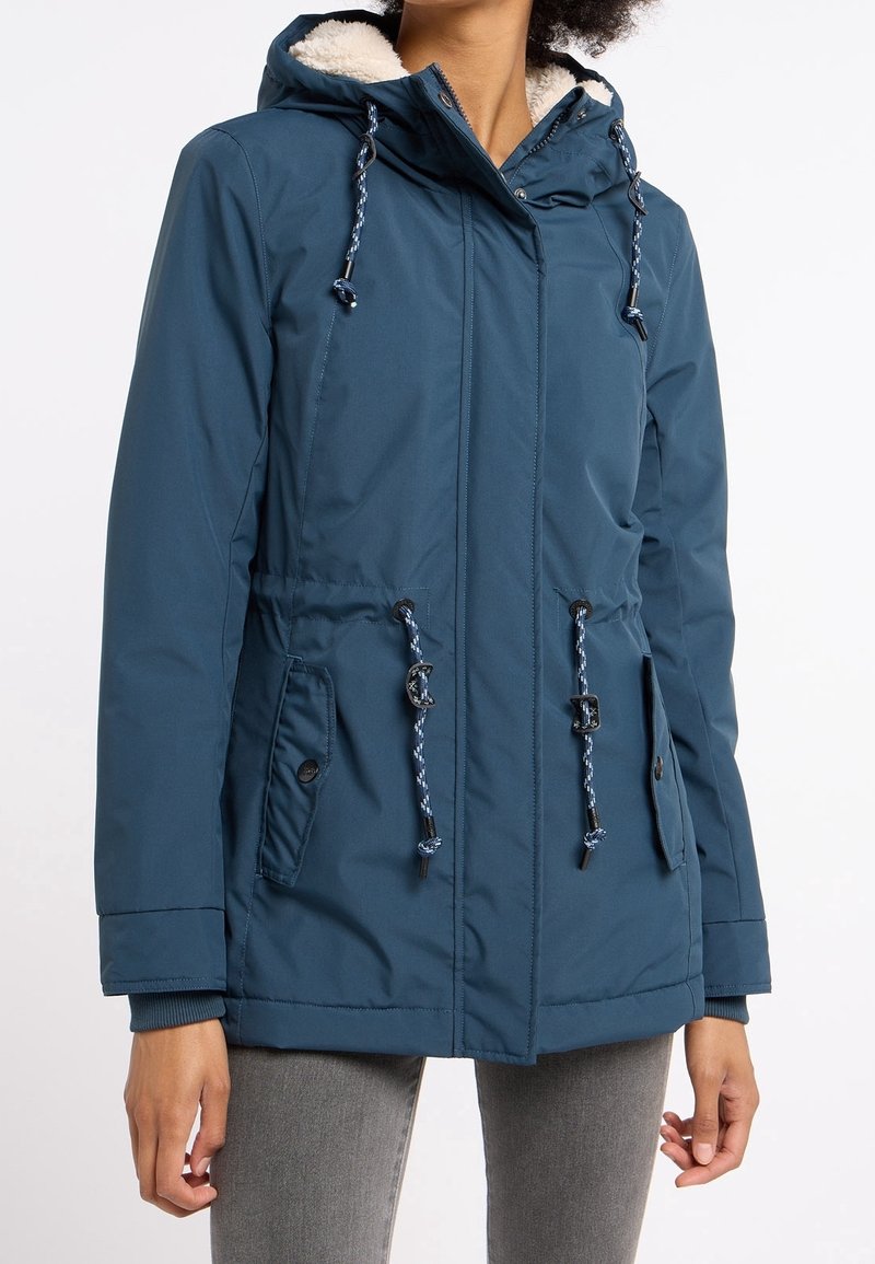 Parka aislante en color azul verdoso con capucha y forro de piel sintética, cintura ajustable con cordón y dos bolsillos frontales con cierres de botón.