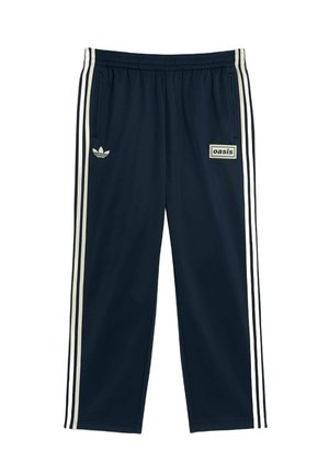 Granatowe spodnie dresowe z lekkiego materiału, z trzema białymi paskami po bokach i małym logo "oasis" z przodu.