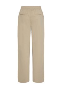 Pantalon beige à jambe droite avec ceinture élastique et deux poches passepoilées à l'arrière, vu de dos.