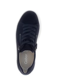 Marineblauwe suède sneaker met witte zool, vetersluiting aan de voorkant en zijritsen, gezien van bovenaf op een witte achtergrond.