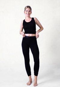 Sort tanktop og leggings sæt med et tætsiddende design, blød tekstur og en sømløs finish. Enkel, essentiel loungewear for komfort.